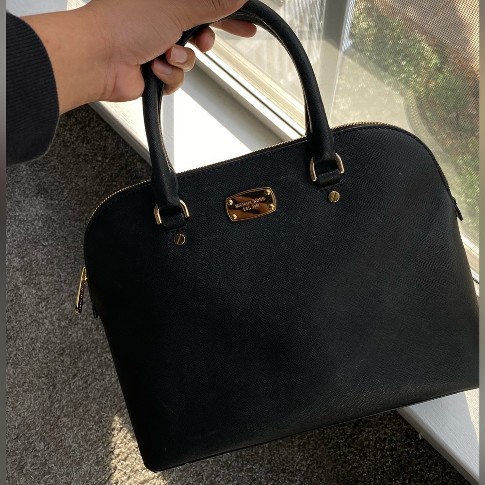 Medium sized black leather Michael Kors purse with gold details.